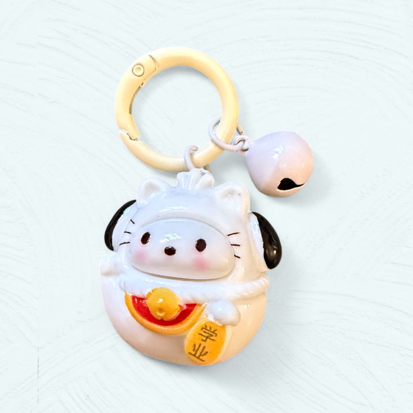 Porte-clés Daruma Pochacco, en blanc avec des oreilles noires tombantes et un visage attendrissant.