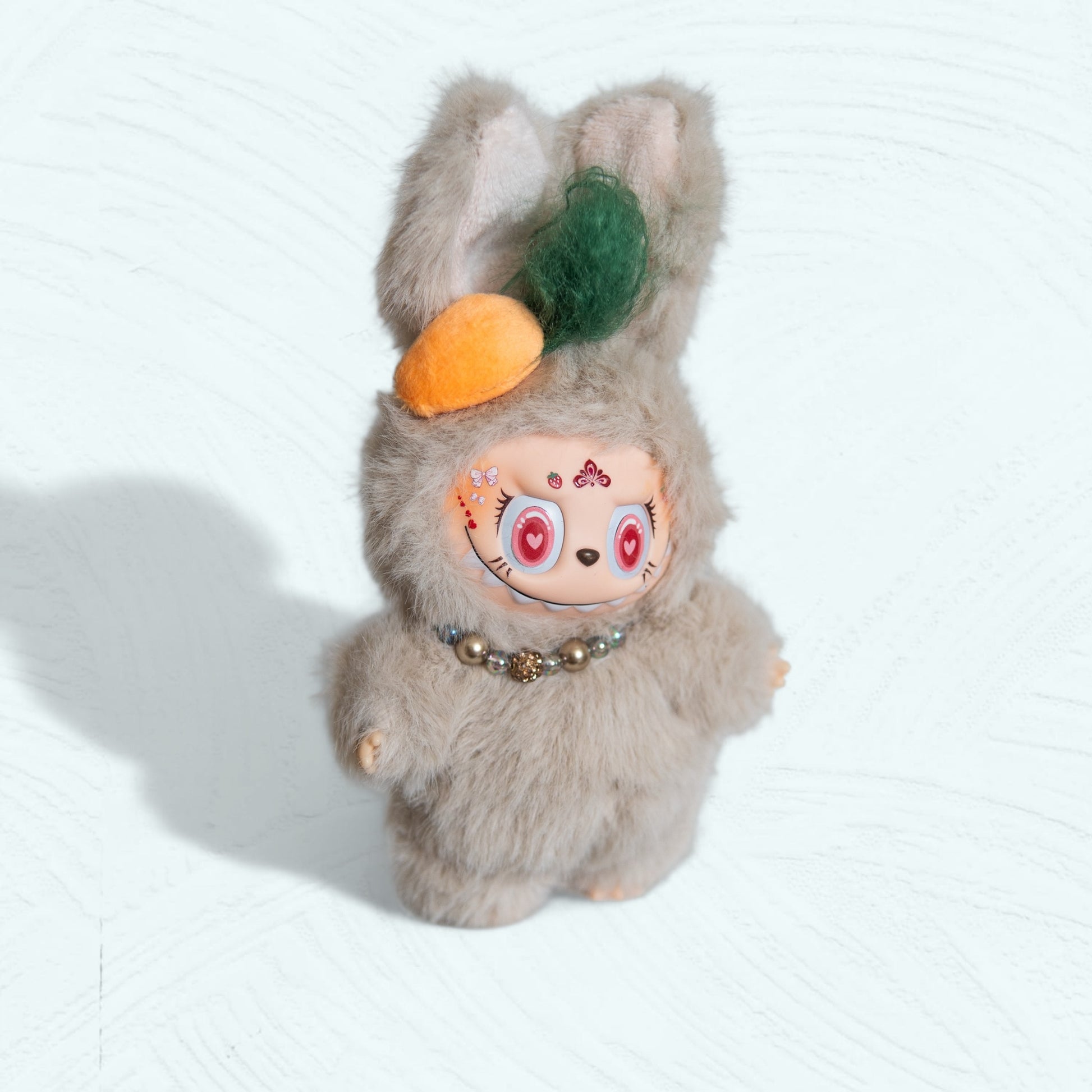 Vue de trois quarts de la poupée Labubu habillée en lapin gris
