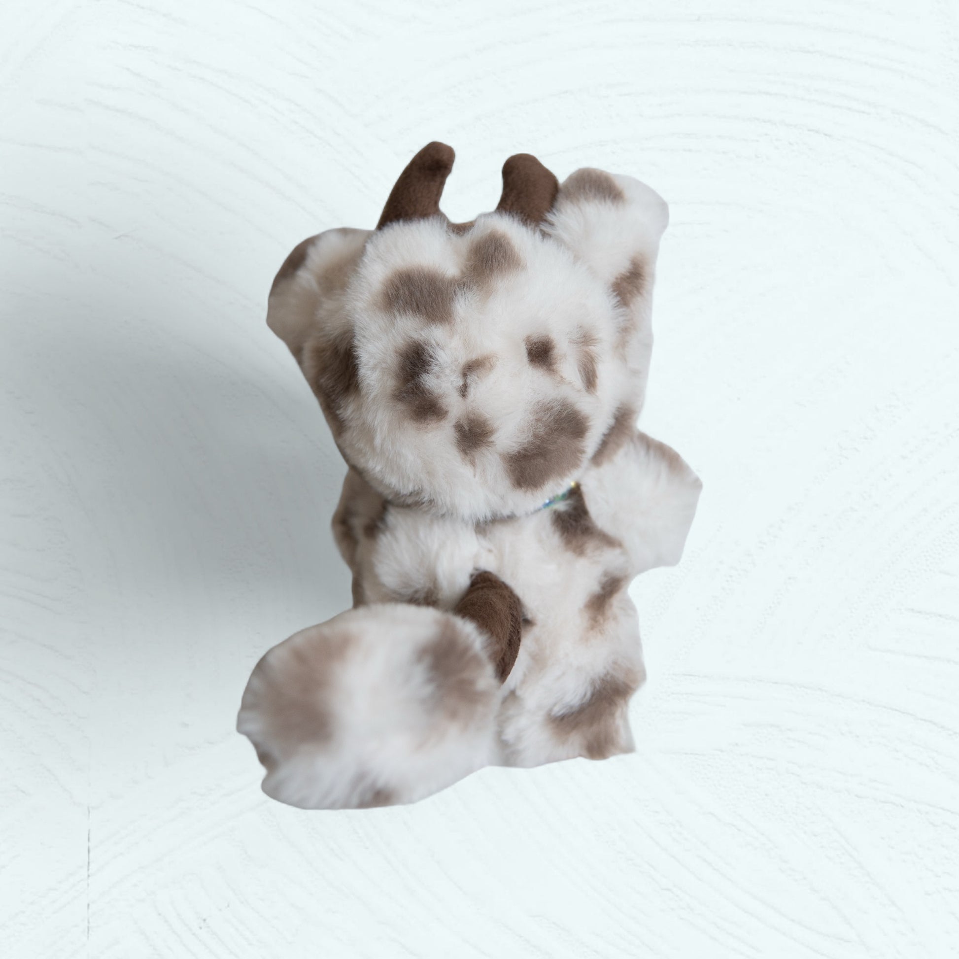 Vue latérale de la figurine Labubu vache avec sa queue et ses cornes.