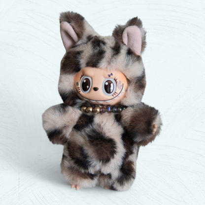 Labubu en costume de léopard vu de face, peluche tachetée et collier de perles.