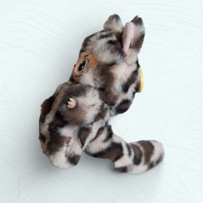 Vue latérale de la figurine Labubu léopard, avec sa longue queue.