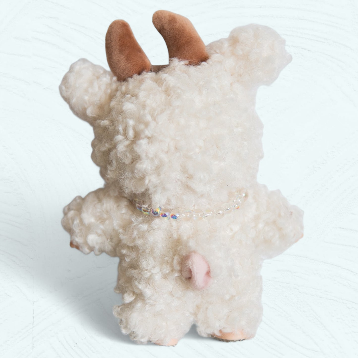 Vue arrière du Labubu en costume de mouton, avec queue et col perlé.