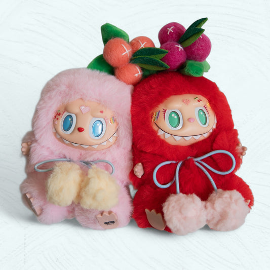 Duo de Labubu costumisés en peluche rose et rouge, reliés par un aimant.