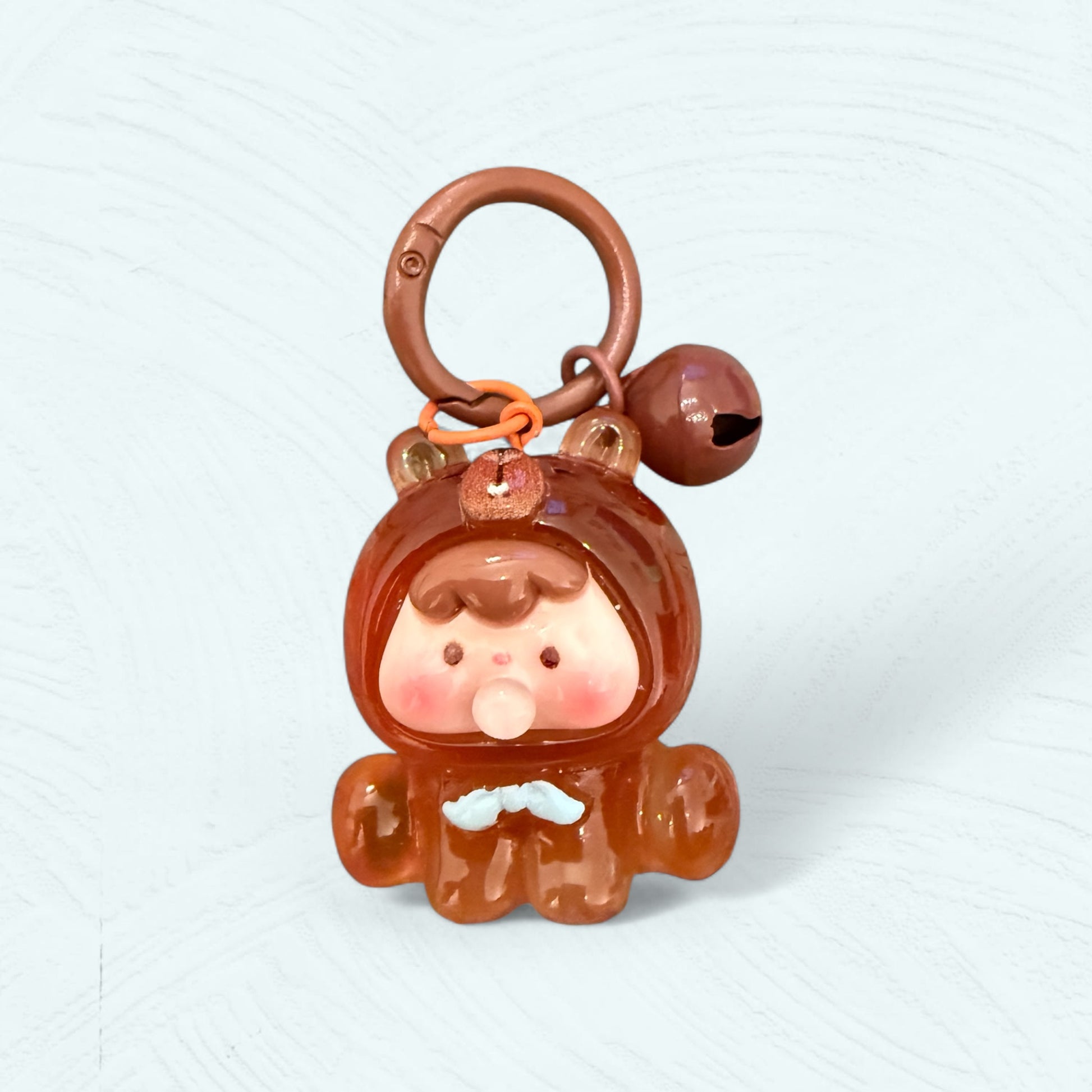 Porte-clés bébé ourson marron avec un petit nœud bleu ciel