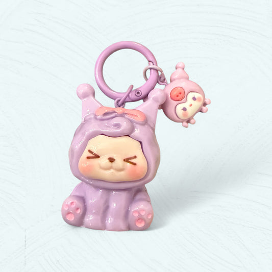 Kiki déguisé en Kuromi avec un mini Kuromi rose suspendu