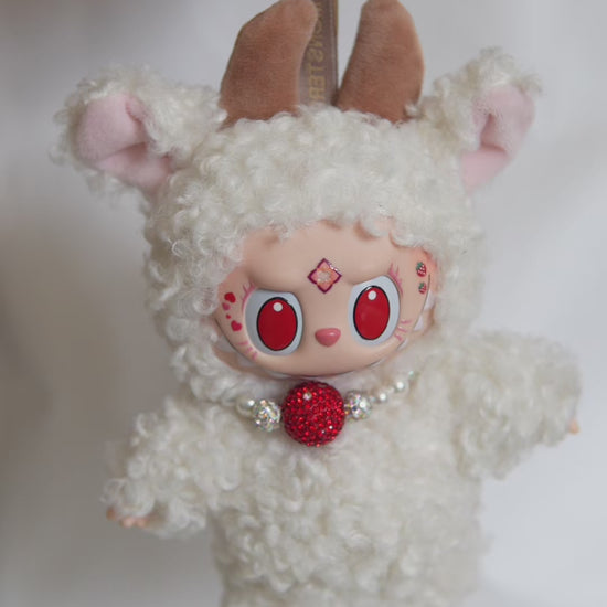 Vidéo du Labubu customisé en mouton : tenue bouclée, collier perlé et cornes en velours.