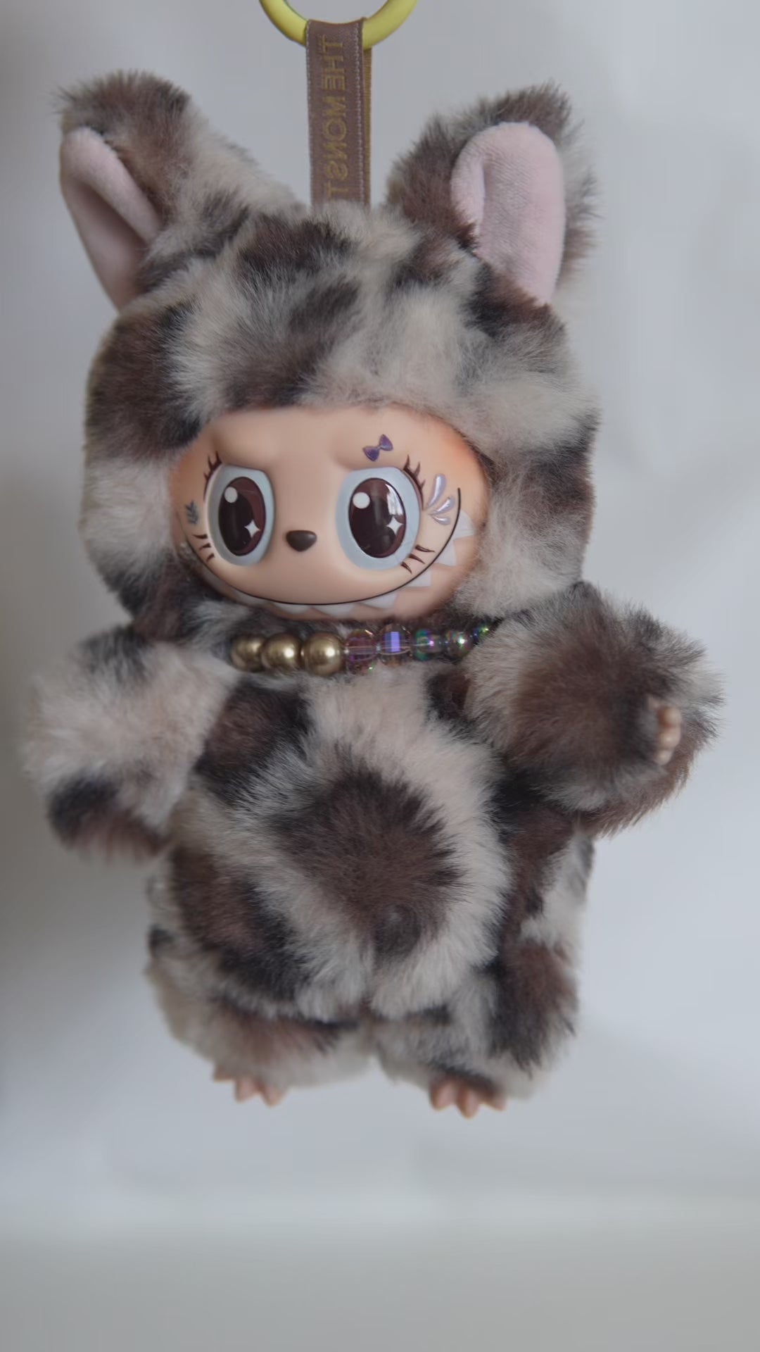 Vidéo de présentation du Labubu customisé en léopard : détails de la fausse fourrure, queue articulée et collier perlé.
