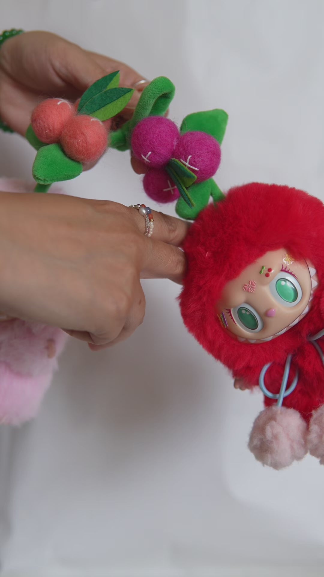 Vidéo de présentation du duo de Labubu costumisés en cerise : détails des costumes en fourrure, pompons et système magnétique.