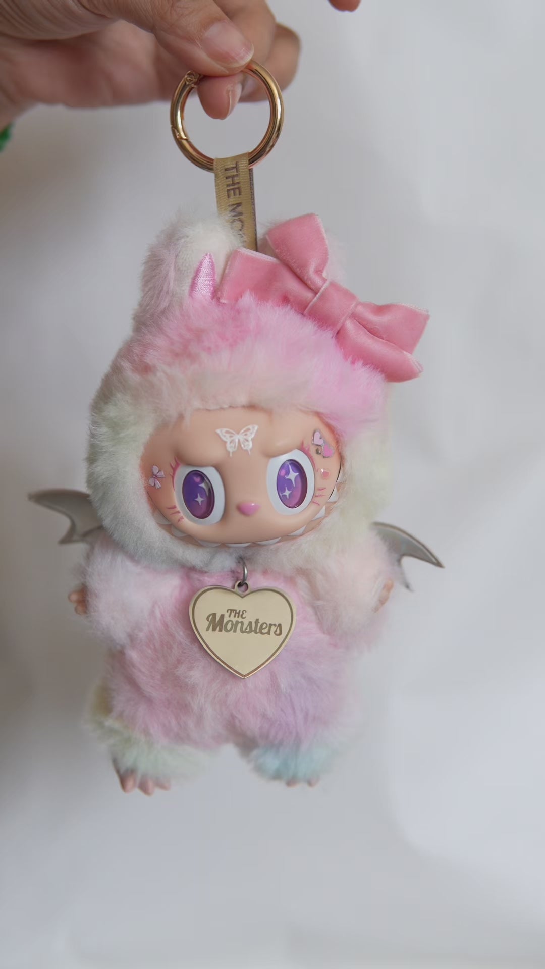 Vidéo de présentation du Labubu customisé en ange pastel avec nœud rose, ailes holographiques et détails perlés.